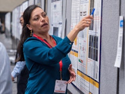 Person pointing to information on a poster