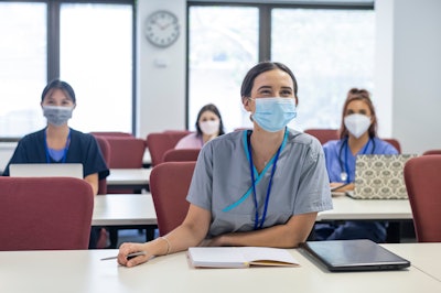Masked medical student learning in a session.