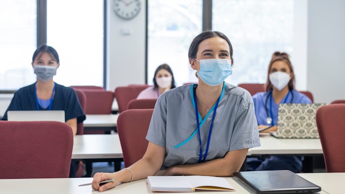 Masked medical student learning in a session.