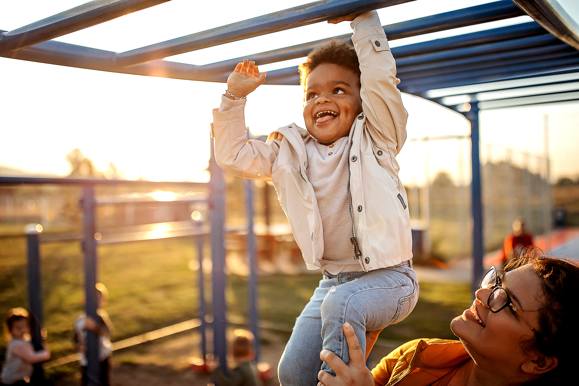 photo of happy multi racial child playing outside with parent