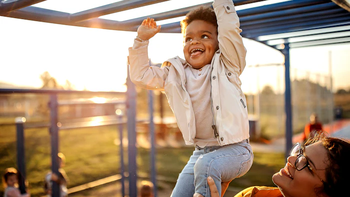 photo of happy multi racial child playing outside with parent
