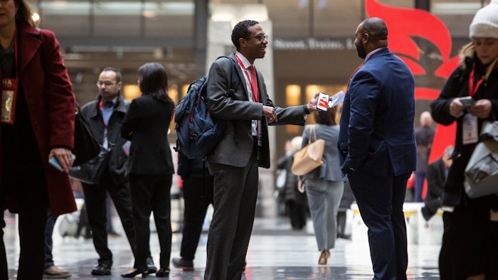Two men talking in a concourse area.