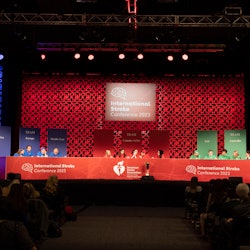 3 Game of Strokes teams sit at a table on stage