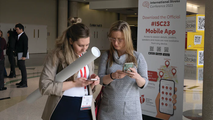 two attendees using their mobile phones