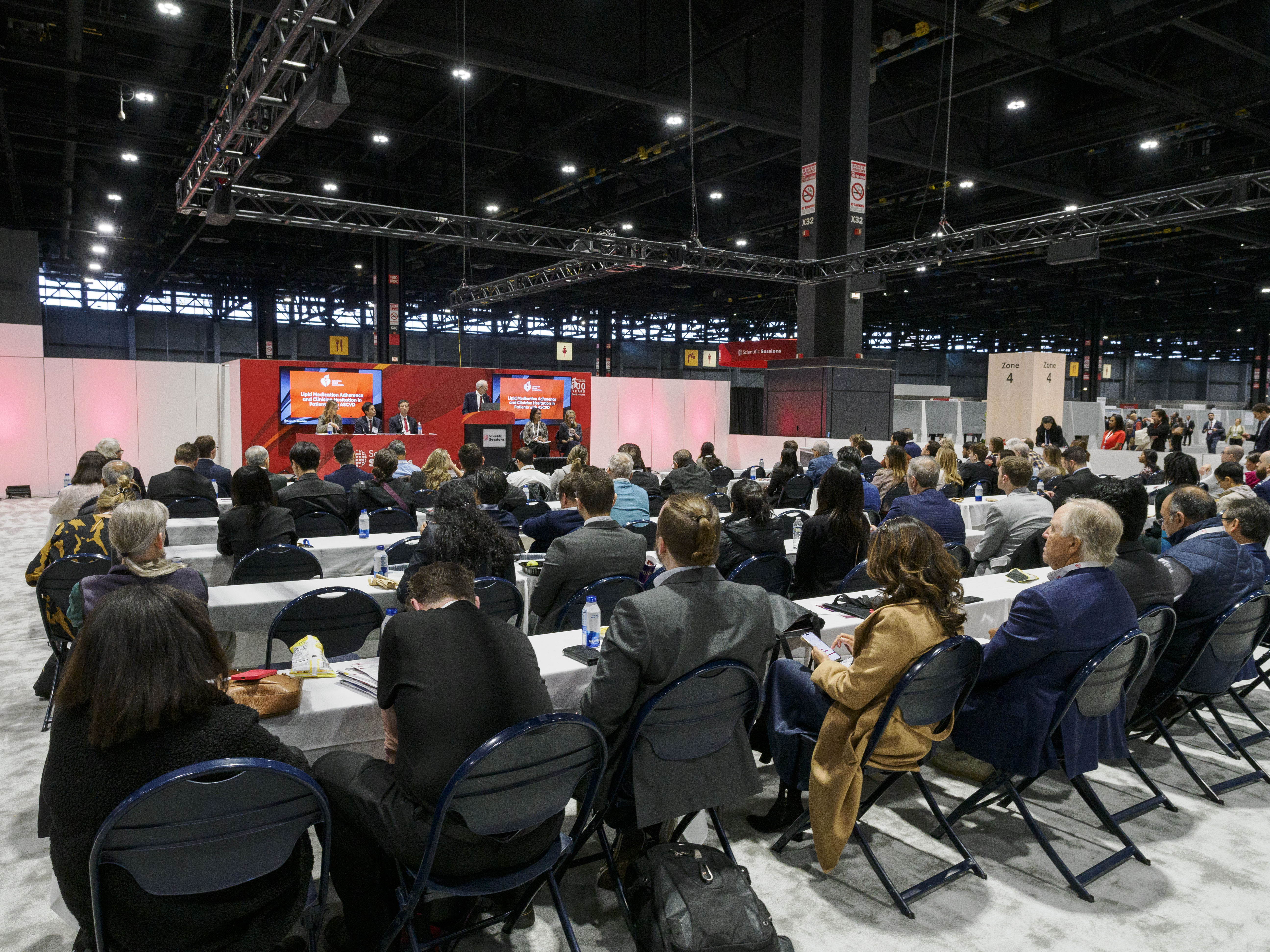 Conference attendees seated in large convention hall during professional presentation