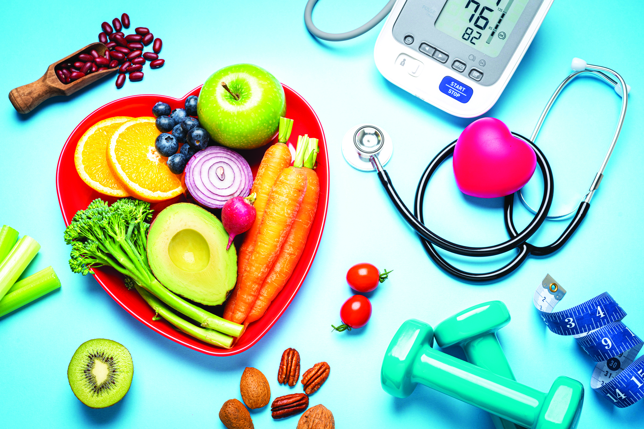 Heart-shaped plate with colorful fruits and vegetables, medical equipment, and fitness tools