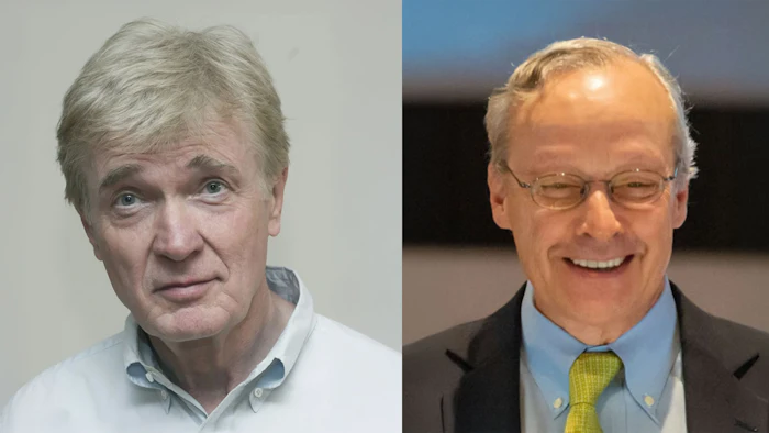 Two mature men in professional attire, one looking serious, one smiling