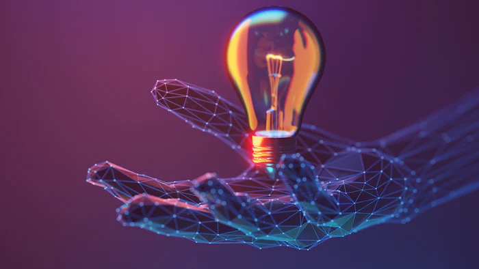 Digital illustration of a glowing lightbulb held by a wireframe hand against a purple gradient background, representing innovation and technology